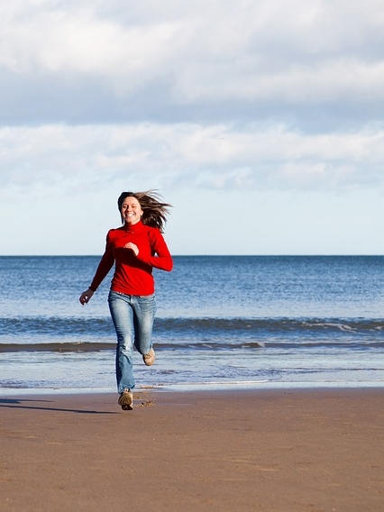 happy woman running beach